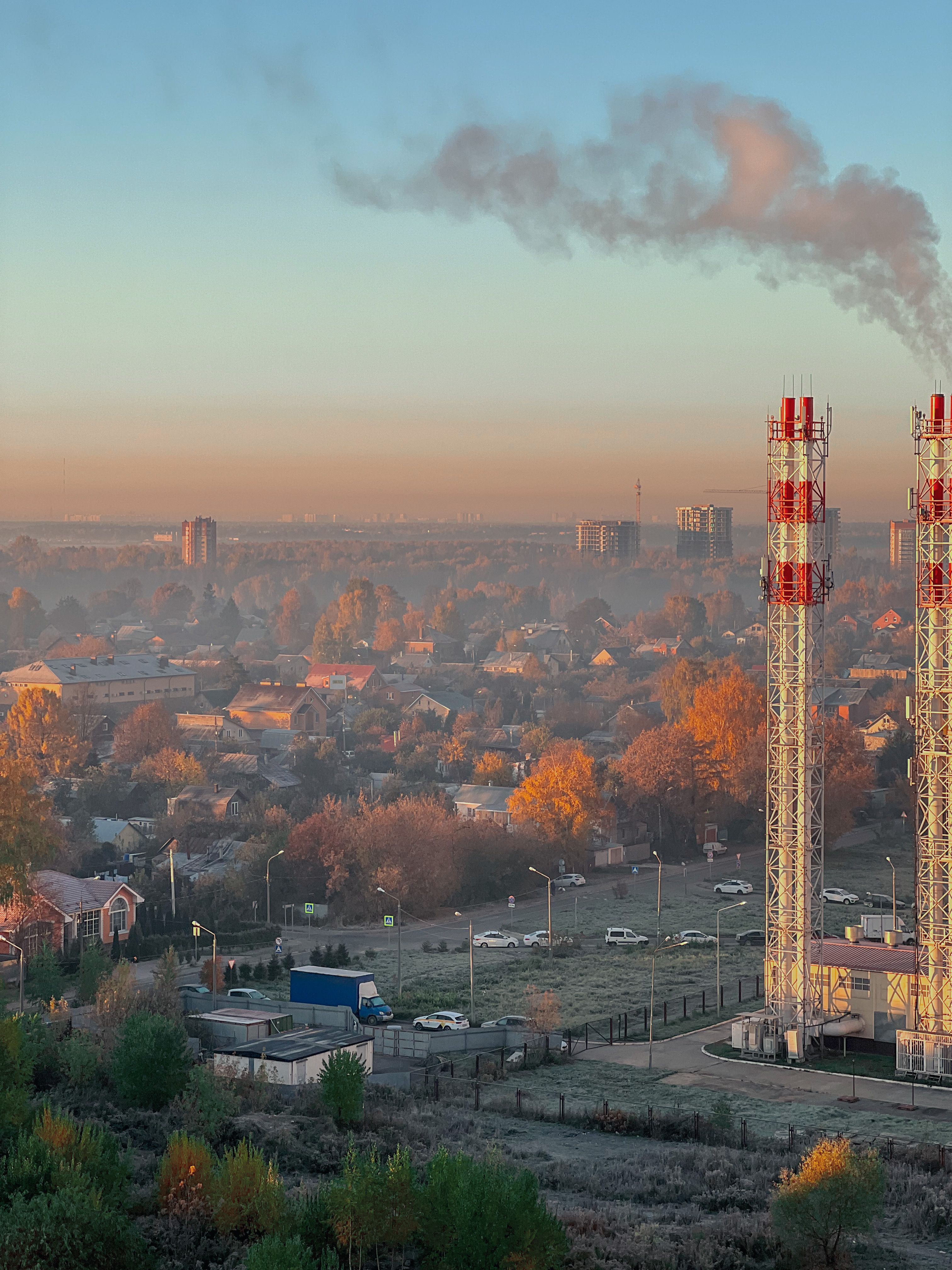 Aerial view of industrial smokestack over a city