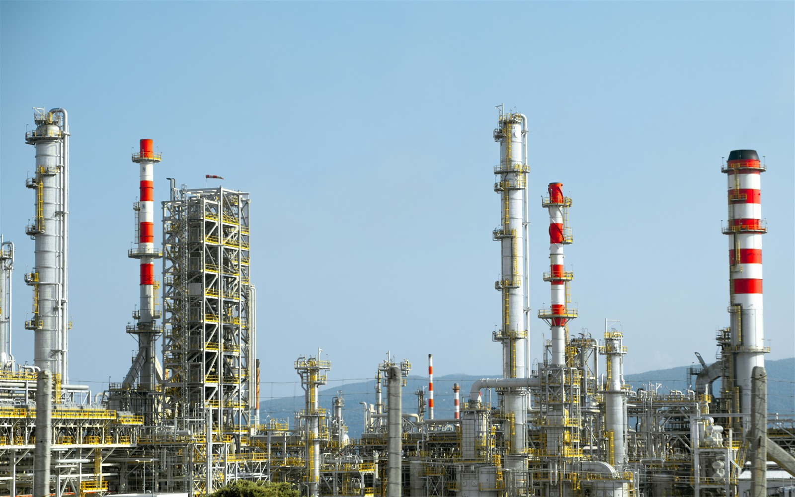 Photo by Christian Harb Oil refinery with rows of distillation towers under a clear sky