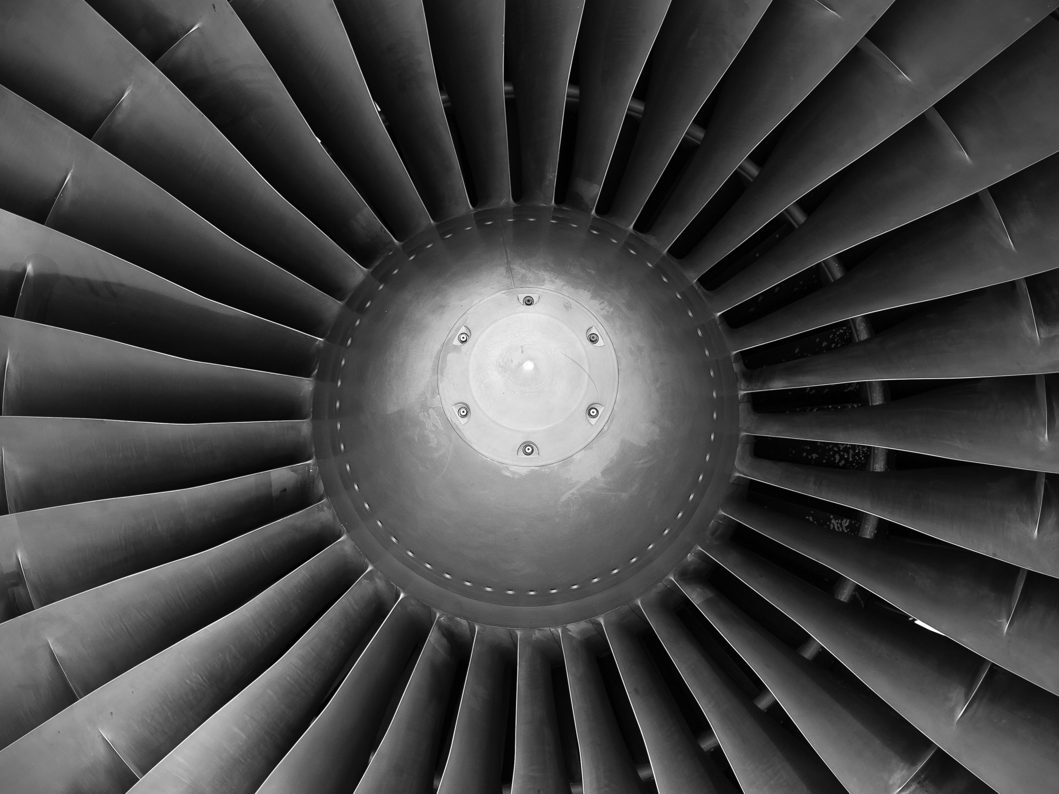 Photo by wwarby on Pexels Close-up of a jet engine turbine fan, black and white